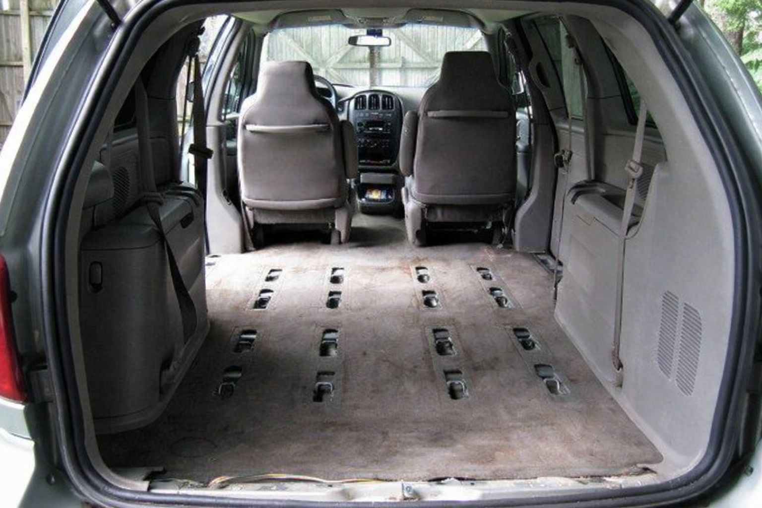 Interiør av en varebil sett bakfra, med seter fjernet og gulvet klargjort.